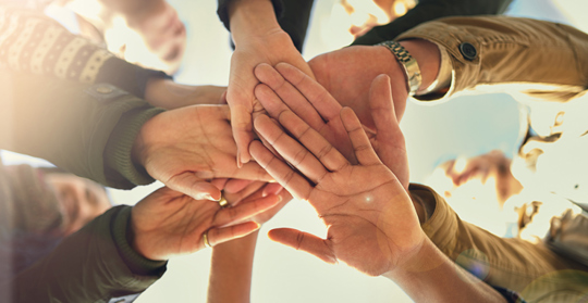 Flera människors händer lagda på varandra